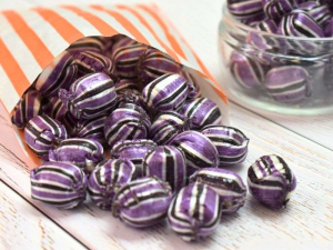 Purple & black striped blackcurrant and liquorice flavour boiled sweets in a paper bag.