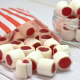White & red clove flavoured boiled sweets in a paper bag.