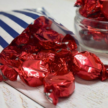 Wrapped buchanans of scotland dark chocolate russian caramels spilling out of a paper bag.
