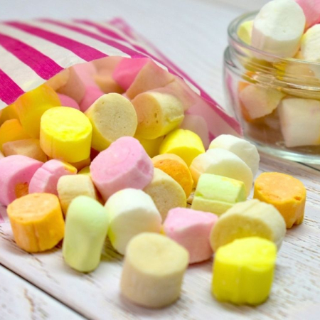 Edinburgh Rock, soft crumbly rock sweets in an assortment of colours spilling from a paper bag
