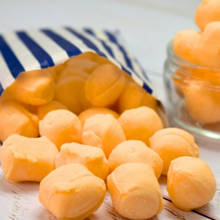 Orange Iron Brew creams spilling from a blue and white striped paper bag.