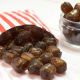 Horehound Rock, brown colour, liquorice and root beer flavoured hard boiled rock pieces spilling from a paper bag